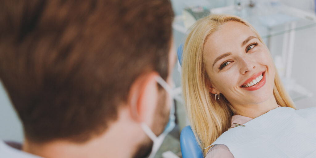 Very nice lady with blonde hair smiling looking at doctors assistant at