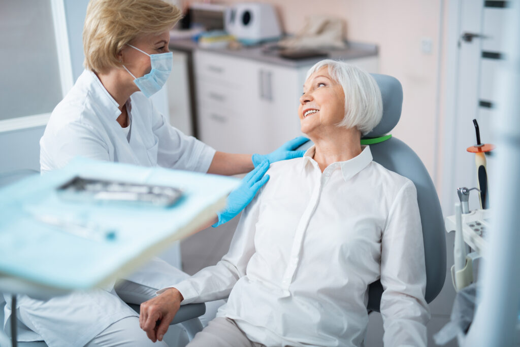 Very nice lady with light hair smiling because her dental implants were take care of at Wellington Family Dentistry & Implant Center