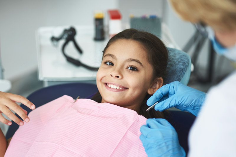 Very nice girl with dark hair smiling at doctor at Wellington Family Dentistry & Implant Center